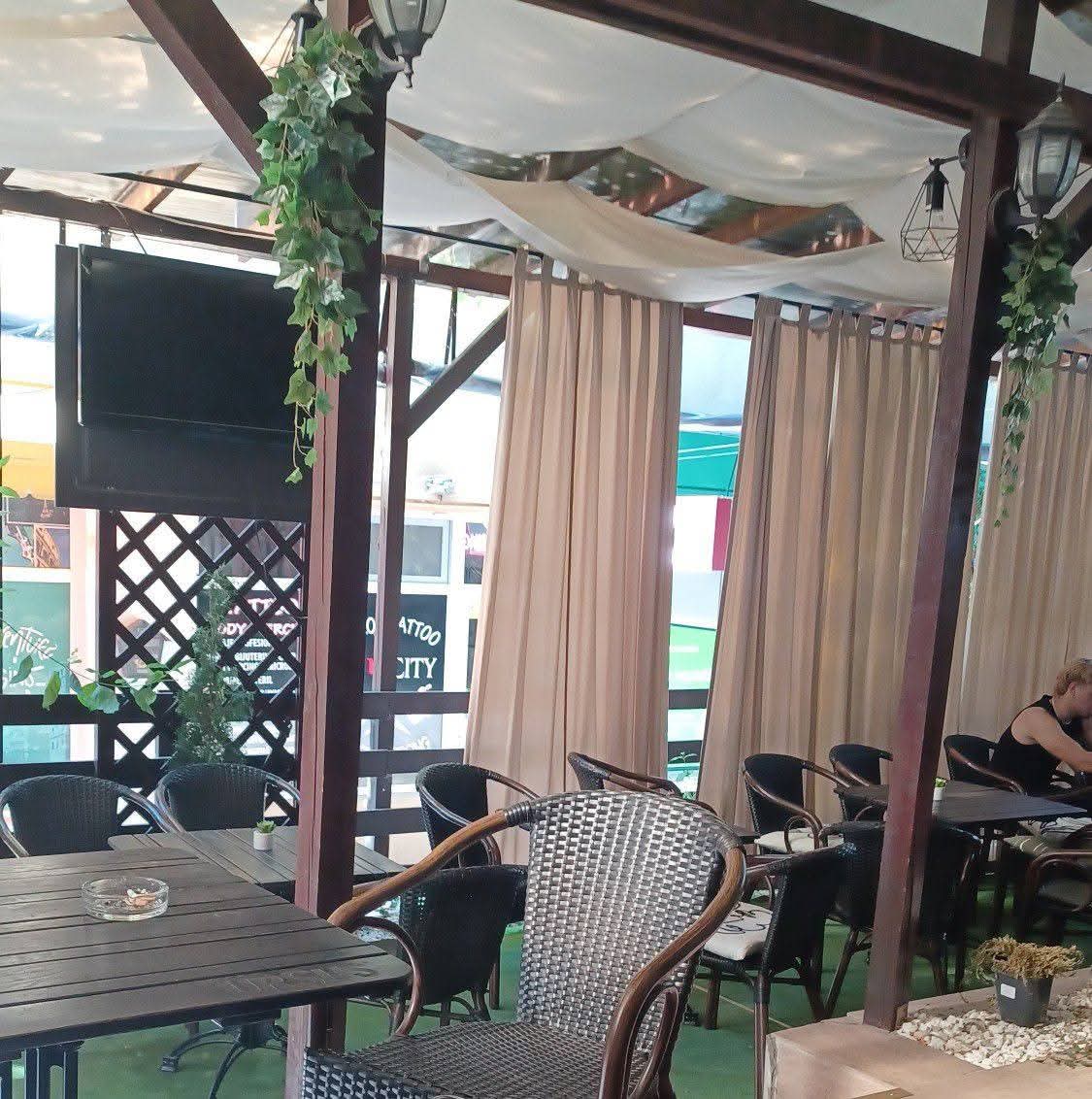 Terasa Cafenelei Opera din Botoșani, cu draperii crem și plante